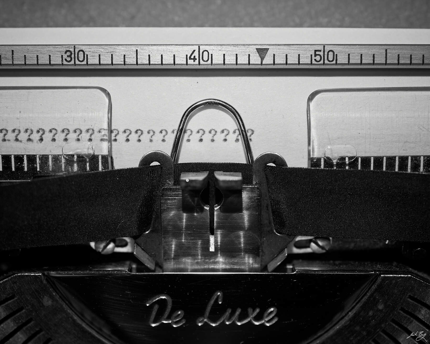 Closeup of typewriter showing a row of typed question marks